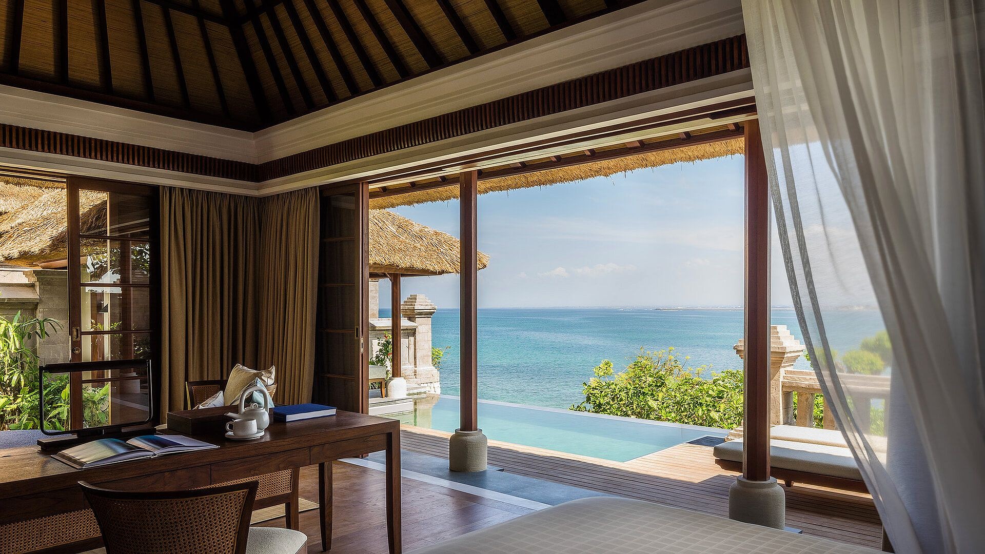 A villa bedroom at Four Seasons Resort Bali at Jimbaran Bay opening onto a private plunge pool and the ocean