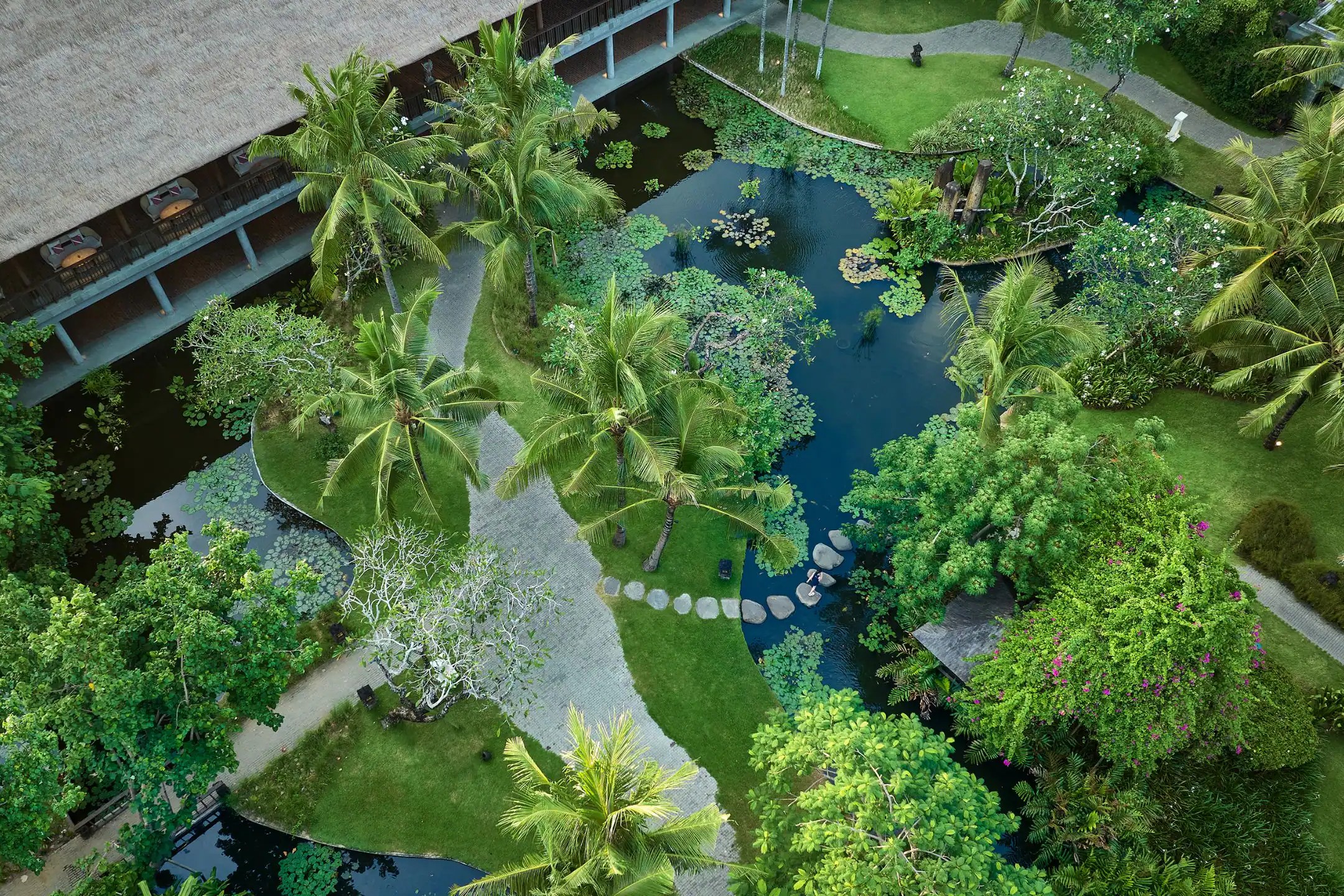 A dense, winding garden path at Hyatt Regency Bali, part of the grounds originally designed by Made Wijaya