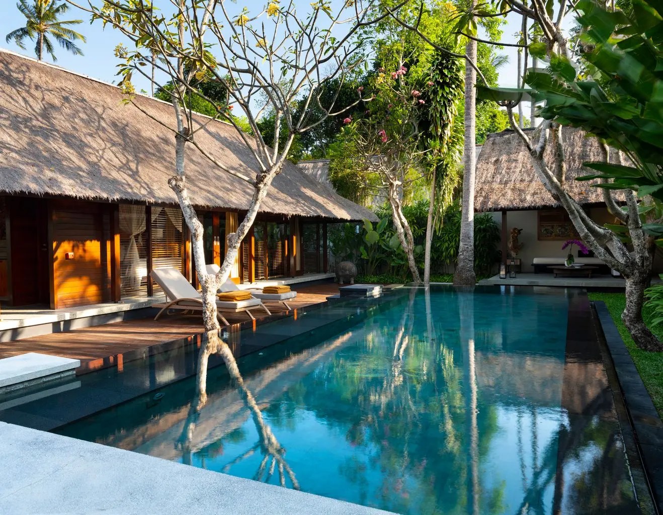 A private pool villa at Kayumanis Jimbaran, framed by thatched roofs and coconut palms