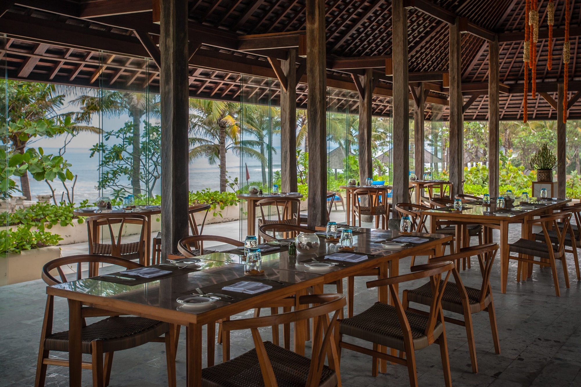 Timur Kitchen, the open-air restaurant at Komaneka at Keramas Beach, set for dinner beside the ocean