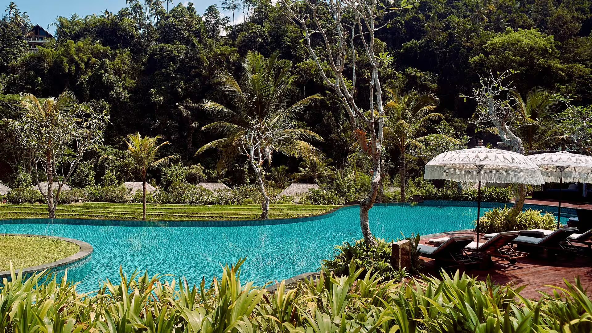 The bamboo dining cocoons of Kubu restaurant at Mandapa, a Ritz-Carlton Reserve, lit up beside the Ayung River