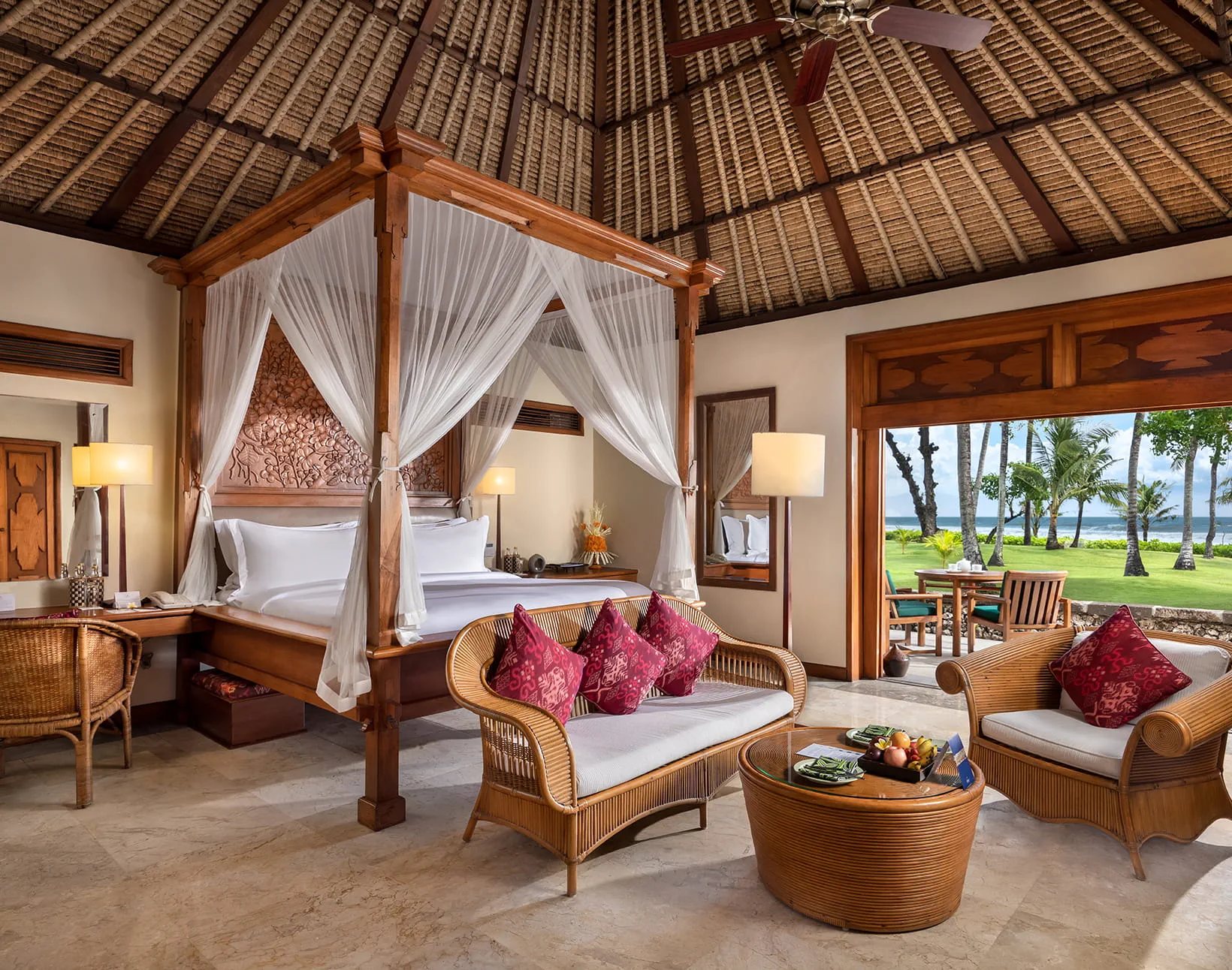 Four-poster bed lanai at The Oberoi Bali with a private terrace opening onto the beach