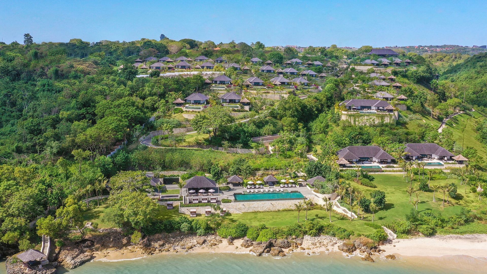 Aerial view of The Raffles Bali's villas spread across the hillside above Jimbaran Bay