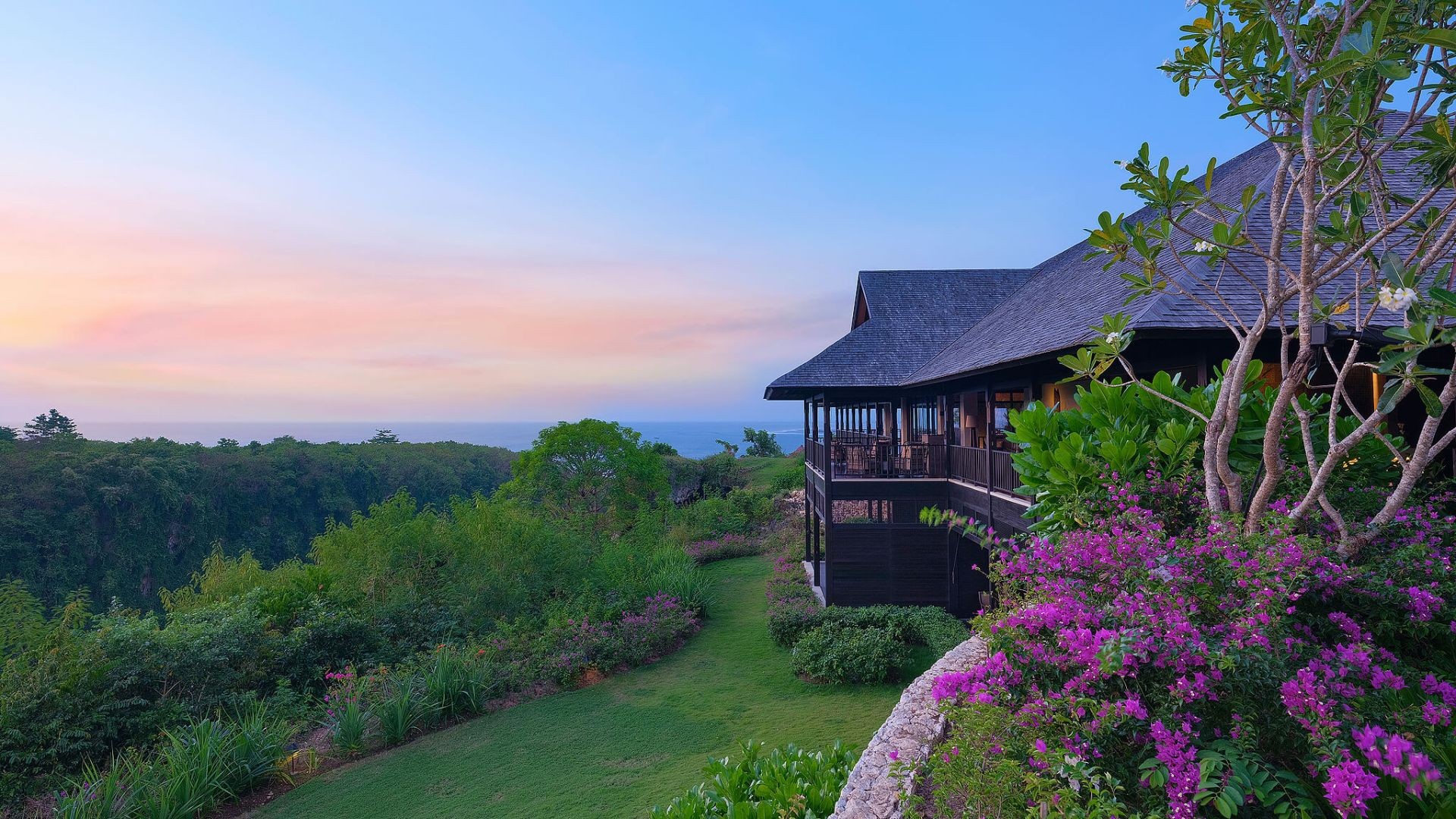 The Raffles Bali's main pavilion at dusk, perched above the valley overlooking the Indian Ocean
