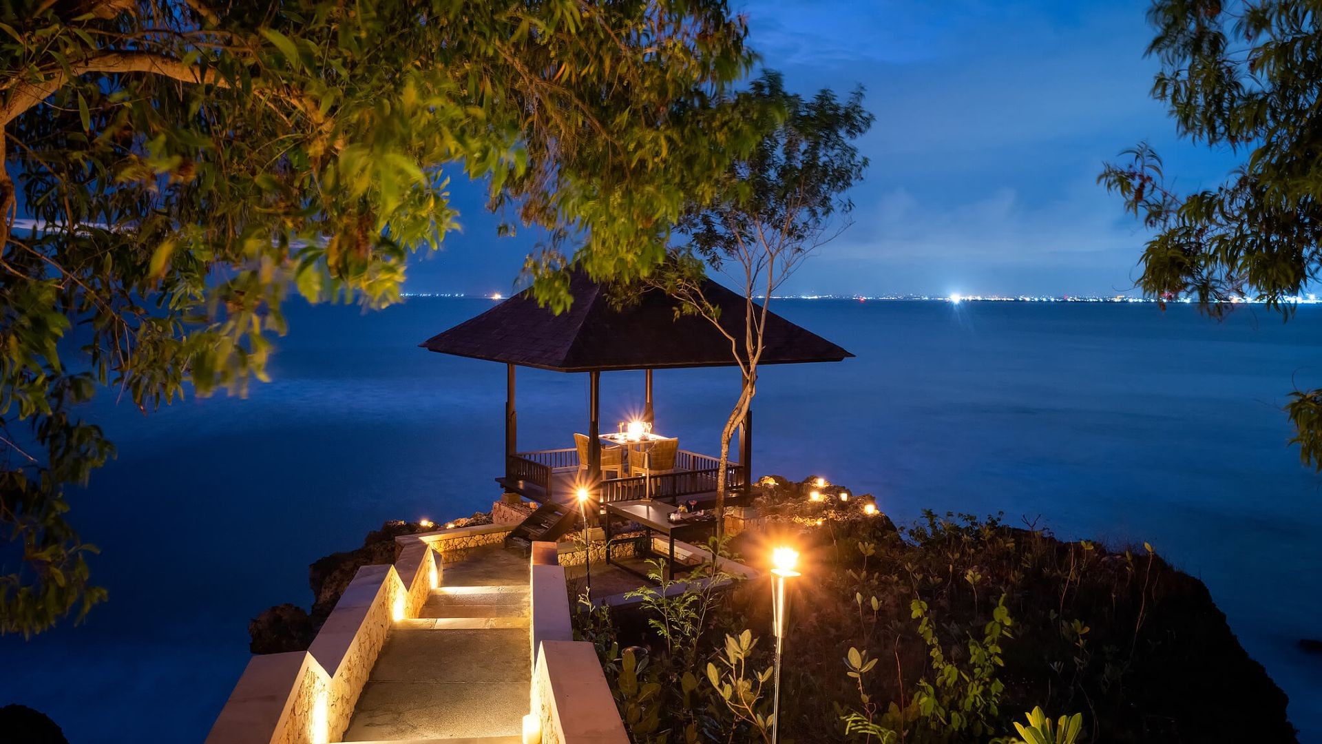The Purnama Honeymoon Bale at The Raffles Bali, lit up above the ocean at night