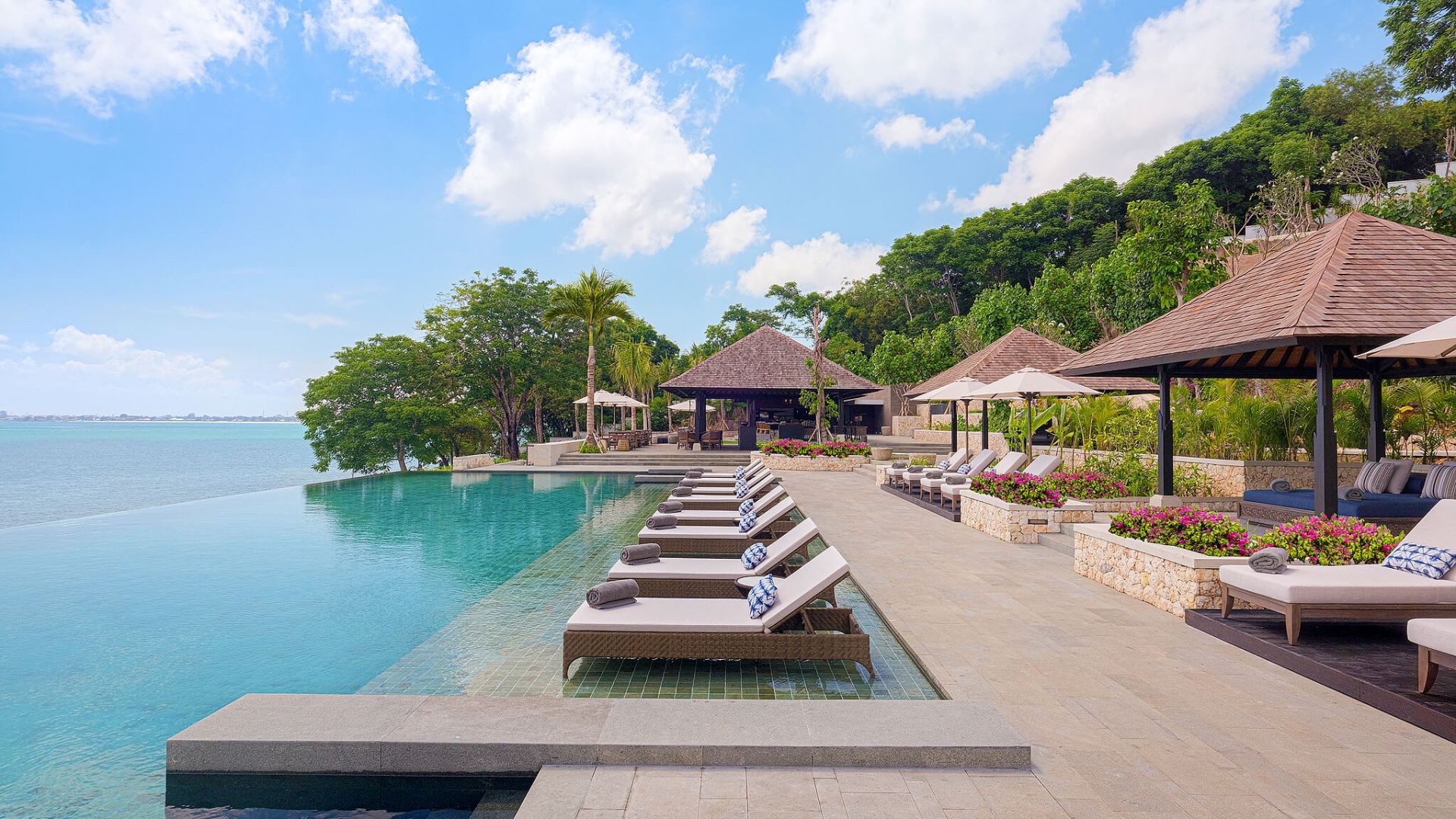 The infinity pool and loungers at Loloan Beach Bar & Grill, The Raffles Bali's private cove